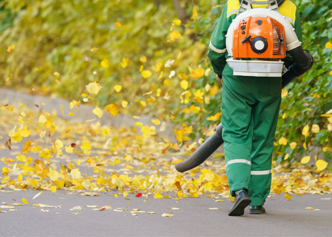 Man leaf blowing in a parking lot